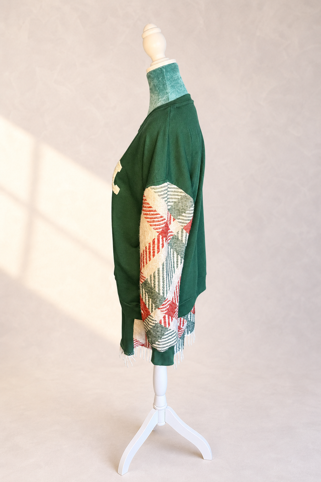 Left side view of The Noel Rework showing the opposite woven textile sleeve and fringed lower panel